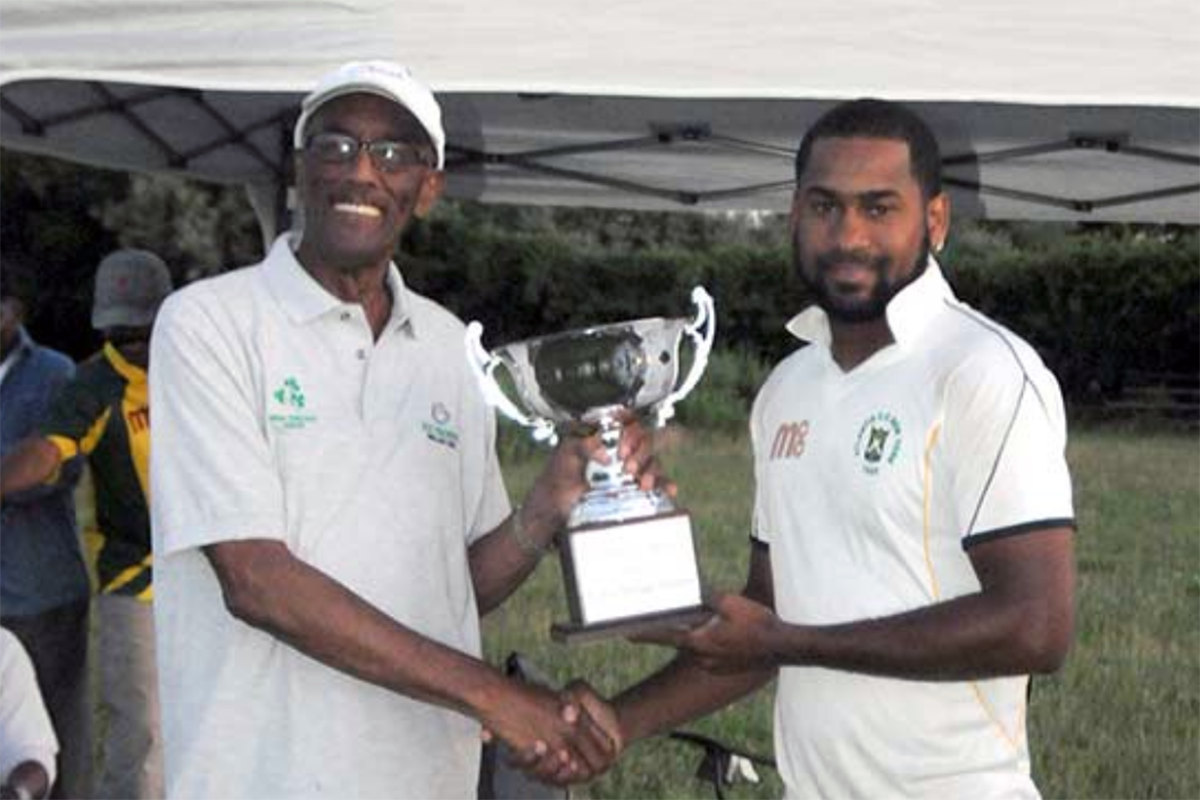 Atlantis' skipper Alex Amsterdam, at right accepts the Andrew Light Memorial Trophy from fromer Guyana and DCC pacer H. Carlyle Miller